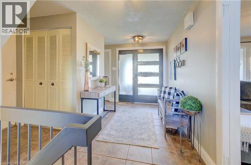Foyer entrance featuring a textured ceiling and light tile patterned flooring - 47 Manor Drive, Kitchener, ON - Indoor Photo Showing Other Room