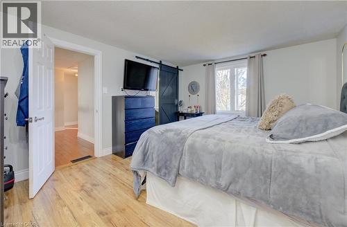 Bedroom featuring a barn door, hardwood / wood-style flooring, and a textured ceiling - 47 Manor Drive, Kitchener, ON - Indoor Photo Showing Bedroom