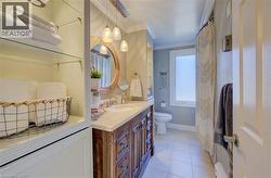 Bathroom featuring vanity, tile patterned floors, toilet, and ornamental molding - 