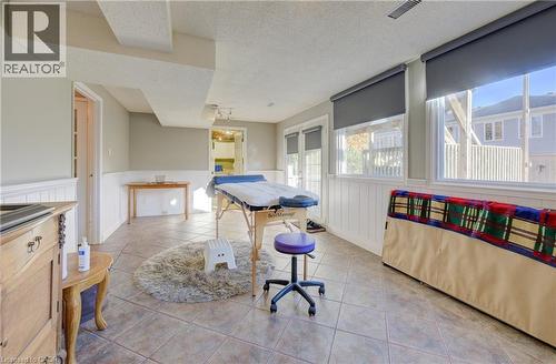 Game room featuring a textured ceiling, light tile patterned flooring, and french doors - 47 Manor Drive, Kitchener, ON - Indoor