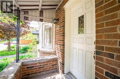 View of exterior entry featuring a porch and brick siding - 136 Glen Road, Hamilton, ON - Outdoor With Exterior