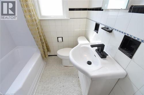 Bathroom with tile walls and shower / bath combo - 136 Glen Road, Hamilton, ON - Indoor Photo Showing Bathroom