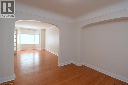 Spare room featuring light wood-type flooring and arched walkways - 136 Glen Road, Hamilton, ON - Indoor Photo Showing Other Room