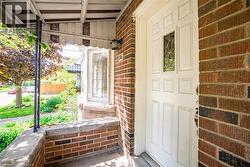 View of exterior entry featuring a porch and brick siding - 