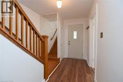 Foyer featuring stairs and dark wood-type flooring - 