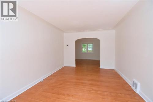 Unfurnished room with arched walkways and light wood-style floors - 136 Glen Road, Hamilton, ON - Indoor Photo Showing Other Room
