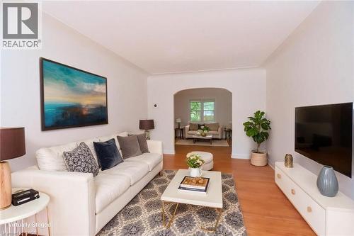 Living area with light wood-style floors and arched walkways - 136 Glen Road, Hamilton, ON - Indoor Photo Showing Living Room