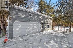 Snow covered property featuring a chimney and a garage - 