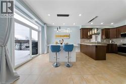 Kitchen with a breakfast bar, decorative light fixtures, tasteful backsplash, and stainless steel appliances - 