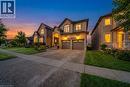 French country inspired facade with a front lawn, driveway, an attached garage, stucco siding, and stone siding - 59 Greti Drive, Hamilton, ON  - Outdoor With Facade 