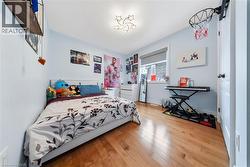 Bedroom with hardwood / wood-style floors and baseboards - 