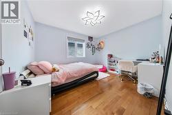 Bedroom featuring hardwood / wood-style flooring and an office area - 