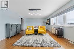 Sitting room with hardwood / wood-style flooring and track lighting - 