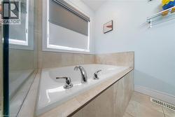 Full bathroom featuring a bath and light tile patterned floors - 