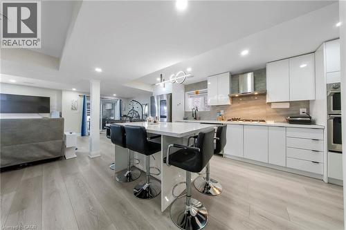 Kitchen featuring modern cabinets, open floor plan, a kitchen bar, white cabinetry, and a center island - 59 Greti Drive, Hamilton, ON - Indoor Photo Showing Kitchen With Upgraded Kitchen