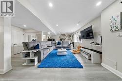 Living room with light wood-type flooring and recessed lighting - 