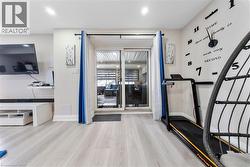 Workout room featuring light wood-type flooring and baseboards - 
