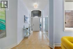Foyer entrance with light tile patterned flooring and arched walkways - 