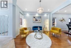 Living area with a chandelier and light wood-style flooring - 