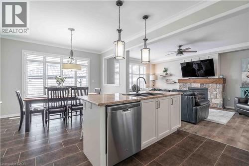 Overall view of primary living space. Note the large patio door to exterior and the custom wood Califormia shutters. - 115 Larry Crescent, Caledonia, ON - Indoor Photo Showing Kitchen With Fireplace With Double Sink With Upgraded Kitchen