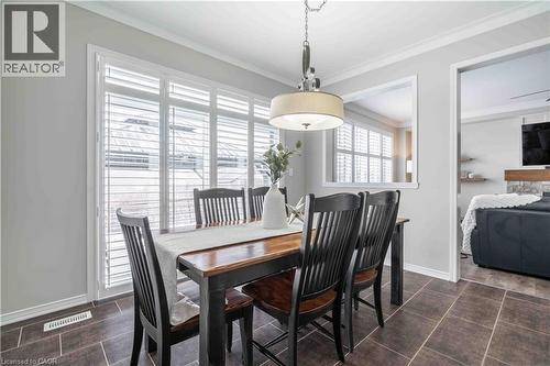 Dining room with ornamental molding, custom California shutters and  tile patterned floors - 115 Larry Crescent, Caledonia, ON - Indoor Photo Showing Dining Room