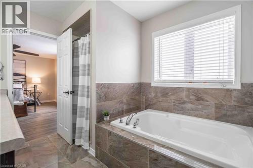 Full bath with a garden tub, a shower with curtain, and marble finish floors - 115 Larry Crescent, Caledonia, ON - Indoor Photo Showing Bathroom