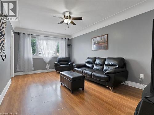 Living room with light wood-style flooring and ceiling fan - 210 East 24Th Street, Hamilton, ON - Indoor Photo Showing Living Room