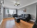 Living room with light wood-style flooring and ceiling fan - 210 East 24Th Street, Hamilton, ON  - Indoor Photo Showing Living Room 