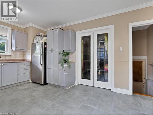 Kitchen featuring freestanding refrigerator, crown molding, french doors, backsplash, and light countertops - 210 East 24Th Street, Hamilton, ON - Indoor Photo Showing Kitchen
