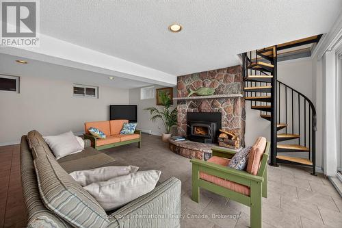 Circular staircase joining upper & lower level - 1420 Tiny Beaches Road N, Tiny, ON - Indoor Photo Showing Other Room With Fireplace