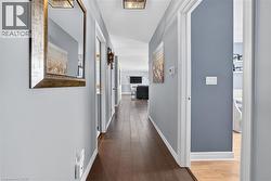 Corridor featuring dark wood finished floors and baseboards - 