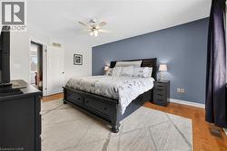 Bedroom with light wood-style floors, ceiling fan, and a textured ceiling - 