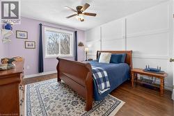 Bedroom with dark wood-style flooring, ceiling fan, and a textured ceiling - 