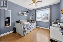 Bedroom with light wood-style floors, ceiling fan, a textured ceiling, and an office area - 
