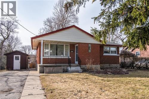 Bungalow-style house featuring a front lawn, brick siding, a porch, and a storage unit - 120 Fourth Avenue, Kitchener, ON 
