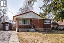 Bungalow-style house featuring a front lawn, brick siding, a porch, and a storage unit - 120 Fourth Avenue, Kitchener, ON 