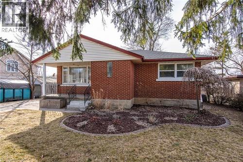 Back of property with brick siding, a yard, and a patio area - 120 Fourth Avenue, Kitchener, ON 
