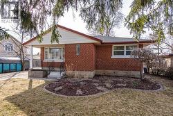 Back of property with brick siding, a yard, and a patio area - 