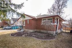 View of side of home with brick siding and a shingled roof - 
