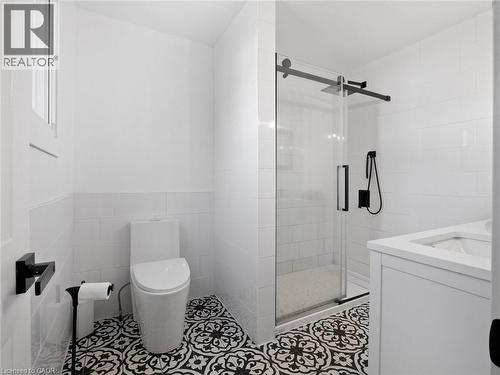 Bathroom with a stall shower, tile patterned floors, toilet, and tile walls - 24 Keefer Road, Thorold, ON - Indoor Photo Showing Bathroom