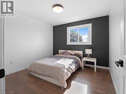 Bedroom featuring baseboards and wood finished floors - 