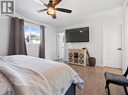 Bedroom featuring baseboards, wood finished floors, and a ceiling fan - 