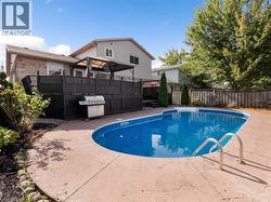 View of pool with a patio, fence, a fenced in pool, and grilling area - 