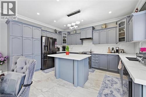 Kitchen with glass fronted cabinets, gray cabinetry, stainless steel appliances, a center island, and ornamental molding - 456 Valridge Drive, Ancaster, ON - Indoor Photo Showing Kitchen With Upgraded Kitchen