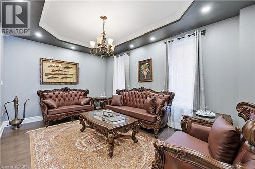 Living room featuring suspended lighting, wood finished floors, a raised ceiling, and crown molding - 456 Valridge Drive, Ancaster, ON - Indoor Photo Showing Living Room