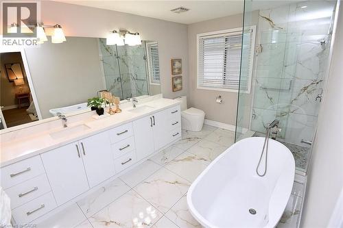 Bathroom featuring a freestanding bath, a marble finish shower, double vanity, and light marble finish flooring - 5109 Blue Spruce Avenue, Burlington, ON - Indoor Photo Showing Bathroom