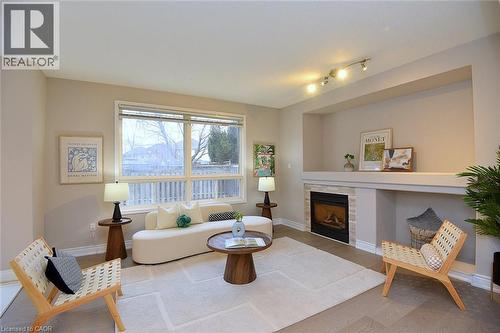 Living area with a tile fireplace and light wood-style floors - 5109 Blue Spruce Avenue, Burlington, ON - Indoor Photo Showing Living Room With Fireplace
