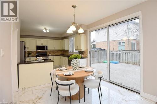 Dining area featuring suspended lighting and light marble finish floors - 5109 Blue Spruce Avenue, Burlington, ON - Indoor Photo Showing Dining Room