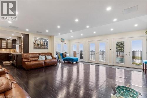 Living room with french doors and dark wood-type flooring - 1073 North Service Road, Hamilton, ON - Indoor