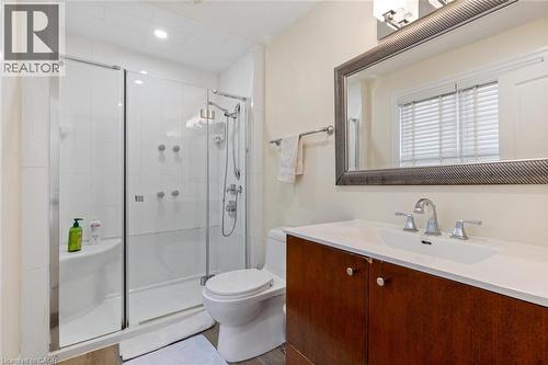 Bathroom featuring vanity, wood-type flooring, an enclosed shower, and toilet - 1073 North Service Road, Hamilton, ON - Indoor Photo Showing Bathroom